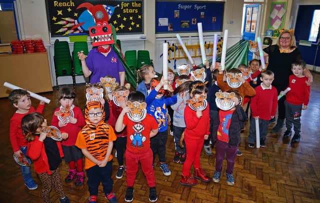 Chinese New Year celebrations at Henry Bradley infants school. Hedghog reception class with Moo Music learning Chinese dancing.
