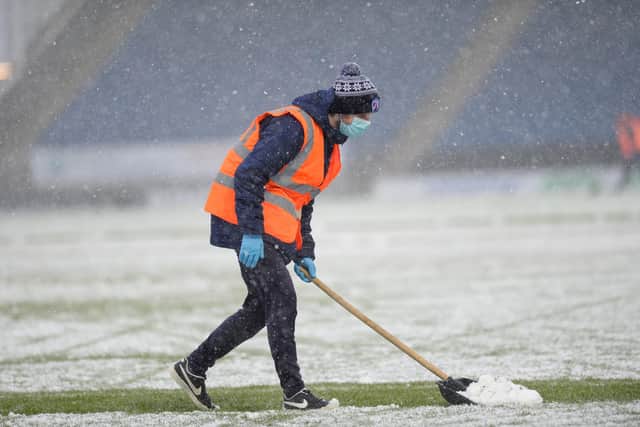 Snow being cleared from the pitch ahead of the game.