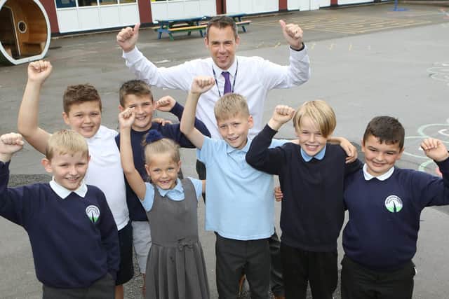 Spire Juniors headteacher Dave Shaw celebrates their recent Ofsted report with pupils from across the school