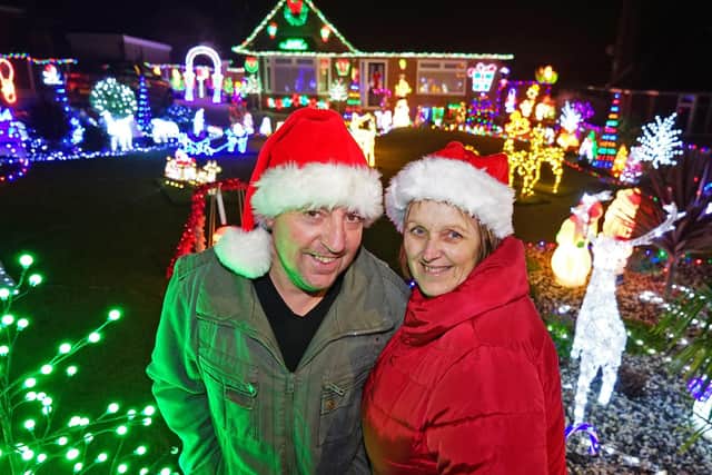 Mark and Julie Peacock from North Wingfield show off their Christmas light display which is raising money for charity.