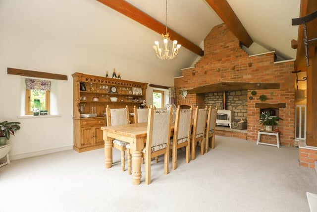 A magnificent brick fireplace  housing a wood-burning stove is a feature of the dining room which has French doors leading out onto a courtyard.