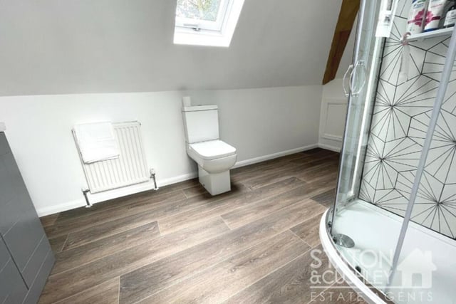 Another of the three en suite bathrooms, attached to the first-floor bedrooms. It boasts a shower cubicle, vanity unit with sink, and low-level WC.