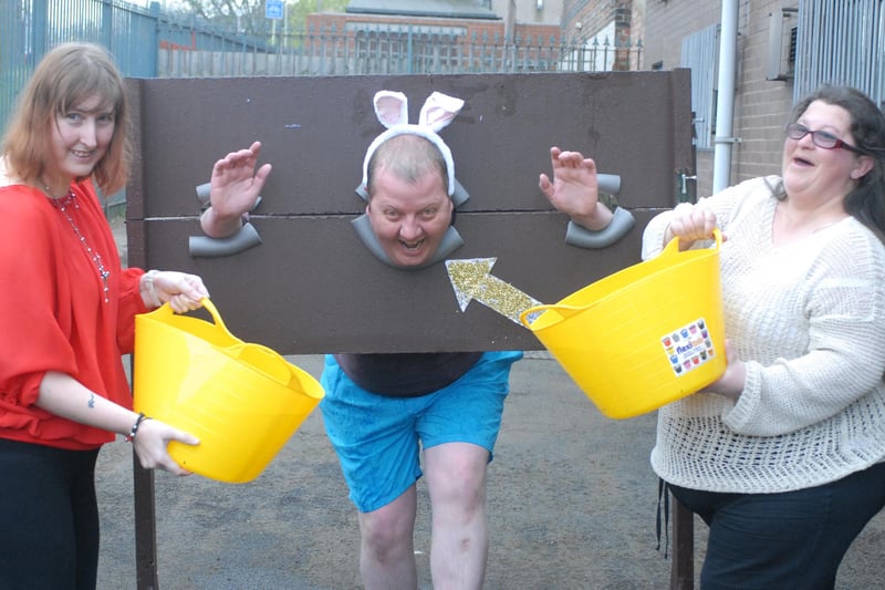 Easter fun at Arts 4 Wellbeing in 2014. Dave Wood is in the stocks and getting a soaking from Judith Dixon and Sharan Falkinder. Who can tell us more?