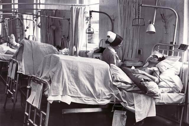 Nurse tending to one of the 11 seriously injured miners after the accident at Markham Colliery in 1973.