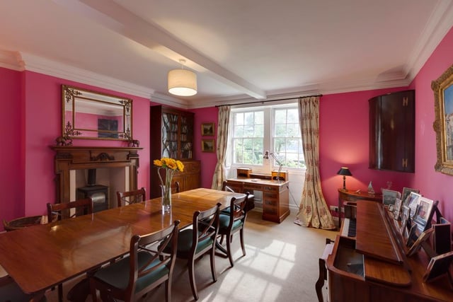 This is the formal dining room - it has double sash windows with fitted shutters and an ornate oak fireplace and granite hearth with a wood burning stove.
