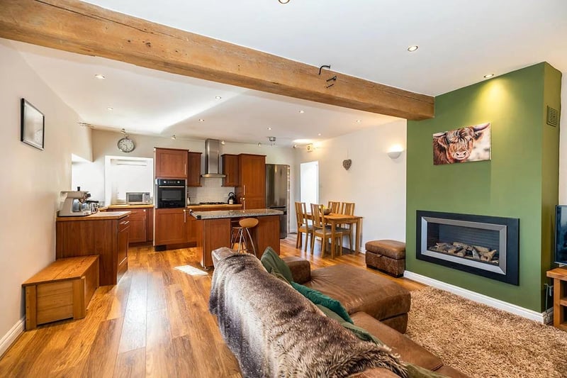 This fantastic open plan room is ideal for those who like to entertain. With high ceilings, wide stone windowsills, and a stone-flagged floor with underfloor heating that is currently covered over with laminate, wood-effect flooring.