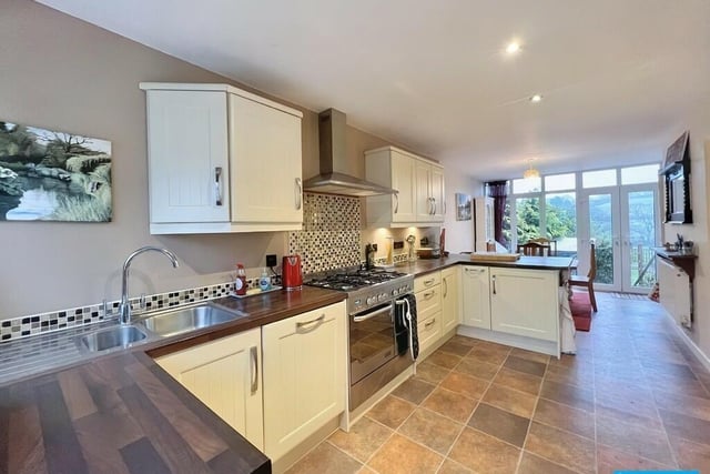 The open-plan layout of the dining kitchen enables light to flood through from the patio doors.  The kitchen has fitted units beneath a wood-effect worksurface with decorative tile splashback. There is a cooker with five-burner hob, fan assisted oven and grill and extractor canopy over. Further fitted cupboards provide storage space with under-cabinet lighting. Integral appliances include an under-counter fridge and dishwasher.