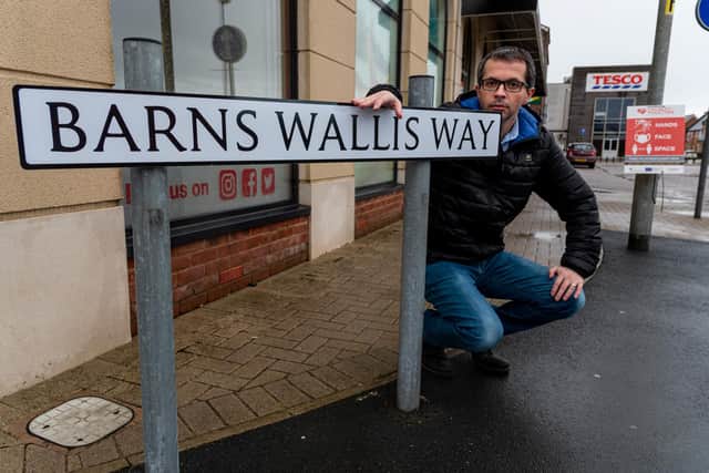 County Cllr Aidy Riggott with the Barnes Wallis Way street sign that has been spelt incorrectly
