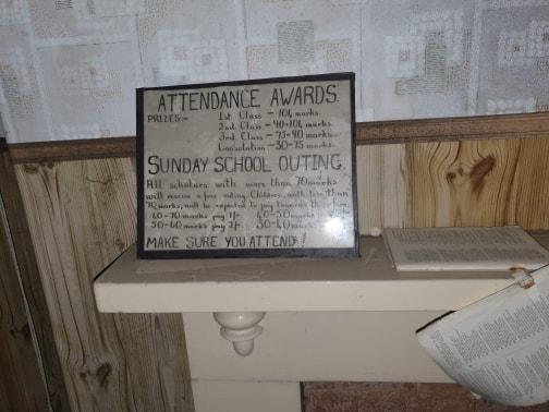 A notice about an outing stands on a mantelpiece