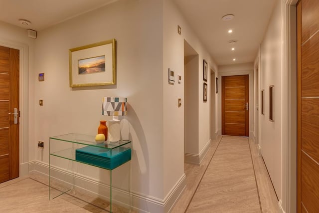 Here's the apartment's entrance hall - it has recessed lighting, fitted full-height vanity mirrors, intercom handset and Karndean flooring with underfloor heating. Walnut veneered doors open to the living kitchen, bedrooms, utility room and family bathroom.