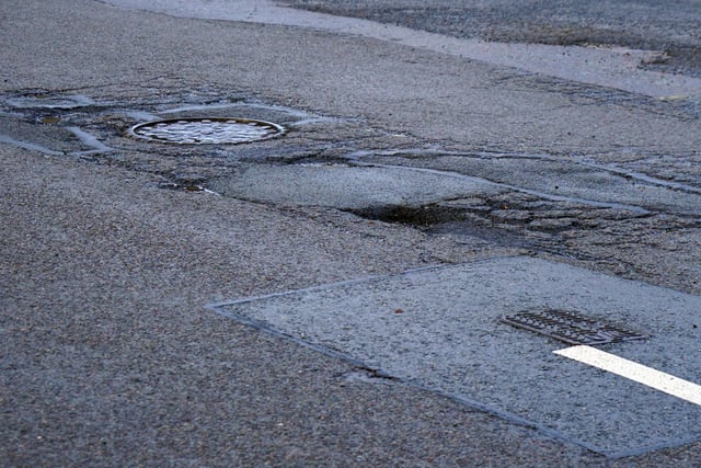 A patchwork of previous repairs can be seen around this pothole on Moor Lane.