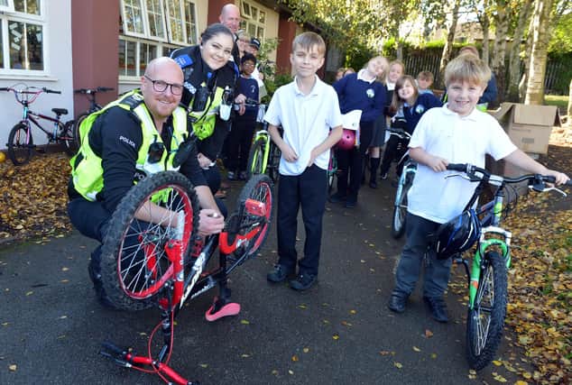 PC Carl Davies and PCSO Alex Jones marking bikes for the safer streets bike marking at Spire Junior School