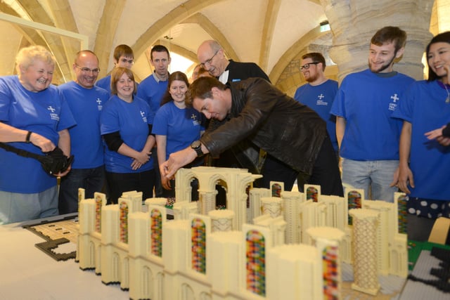 TV presenter and architect George Clarke places a piece of Lego on the replica of Durham Cathedral,  watched by the Dean of Durham Rev. Michael Sadgrove and some of the Volunteer Durham Cathedral Lego Makers. Were you there for the event in 2013?