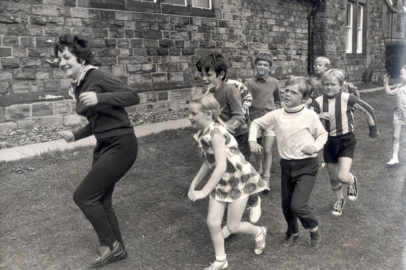 Margaret Andrews leads a game of "follow my leader" at the Eagle Youth club, Newbold ,Chesterfield during a play scheme on August 9, 1971
