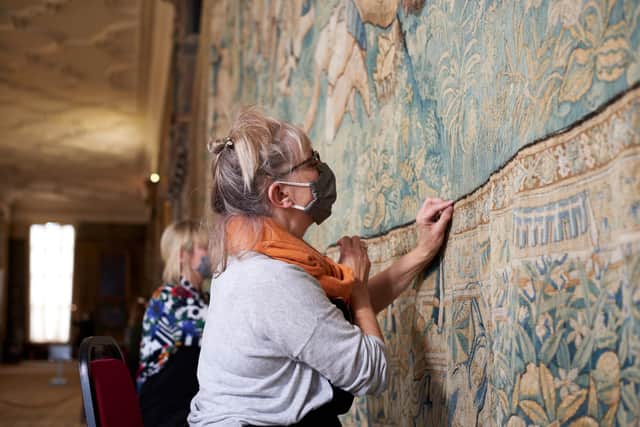 Textile conservators from the National Trust sew the lower border of the 400 year old tapestry. Photo by Trevor Ray Hart/National Trust.