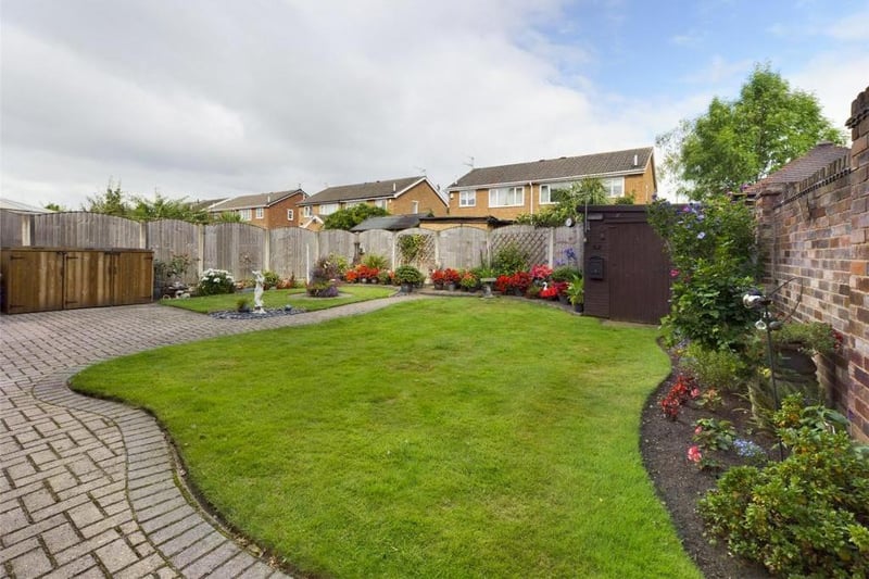 Rear garden - Fence enclosed, laid to lawn with block paved path and raised patio area, flower beds with a variety of plants, flowers and shrubs; timber garden shed, external lighting and garden tap.