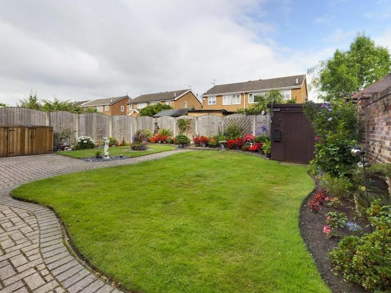 Rear garden - Fence enclosed, laid to lawn with block paved path and raised patio area, flower beds with a variety of plants, flowers and shrubs; timber garden shed, external lighting and garden tap.