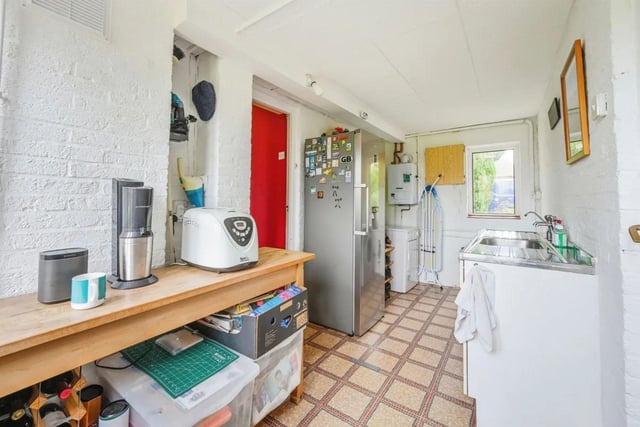 The kitchen is equipped with base and wall cupboards, stainless steel sink unit and ceramic tiled walls. There is space for a cooker and dishwasher.