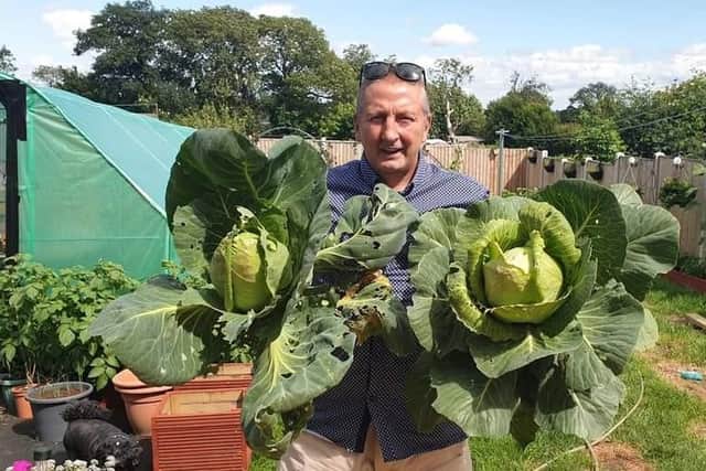 Dean Robert with cabbages grown in his garden.