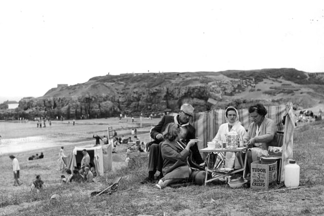With the windbreaker at their backs, the box of Tudor crisps, sandwiches and a cuppa, this family is all set for a great day out by the sea in 1964.