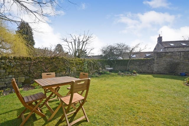 This garden is mainly  laid to lawn, has a pond and is enclosed by a stone wall.