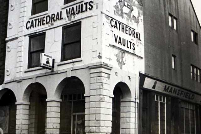 Fronting the Market Place,  the Cathedral Vaults was affectionately known as 'Pretty Windows' in the Seventies due to its coloured panes of glass. The pub closed in 1976. Peak Pharmacy now occupies the site.