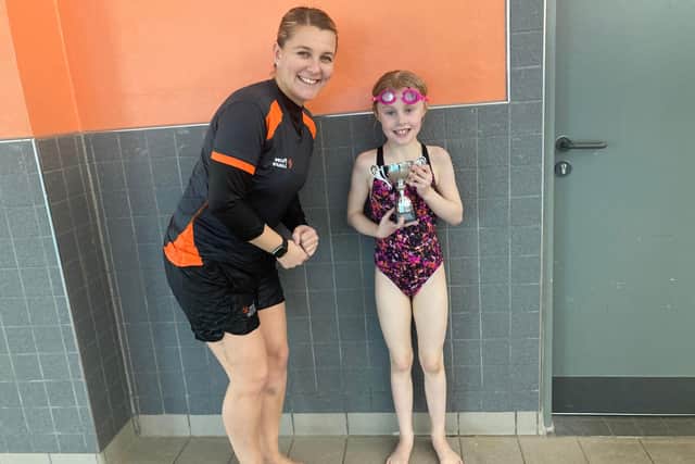 Seven-year-old Iris Maskrey, who completed a sponsored swim for Ukraine, with swimming instructor Shannon Arnold.