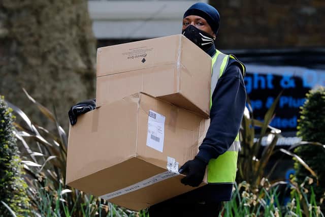 A Hermes delivery courier carries boxes as he makes a delivery. Photo by TOLGA AKMEN/AFP via Getty Images.