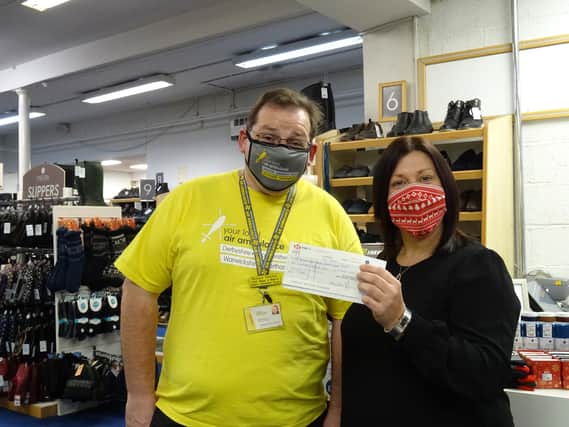 Rachel Brown, store manager at Pavers Shoes in Belper, presents the cheque to Richard Fletcher , voluinteer Derbyshire community representative for DLRAA.