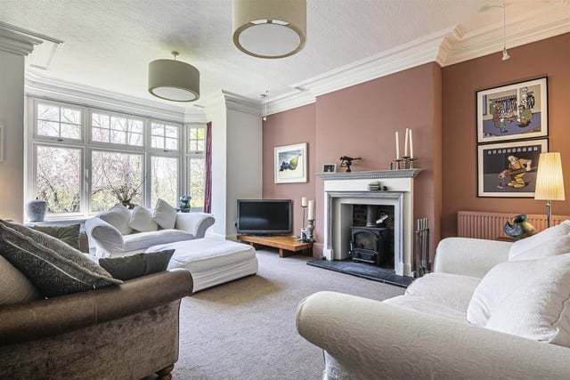 The stylish sitting room has a feature fireplace and a bay window which looks out onto the garden.
