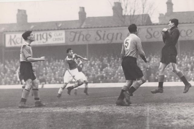 Watched anxiously by his team-mates Gill and Lee, Jones, the Chester goalkeeper, grabs a free-kick from Chesterfield's Clarke, in a scene from the FA Cup game at Saltergate in 1955