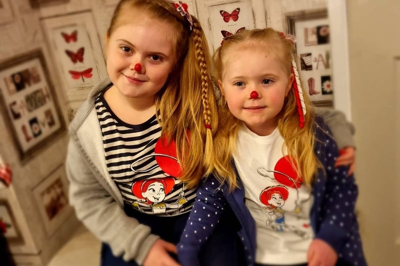 Beighley-Mae, aged eight, and Charlotte, aged four, show their support with red noses and hair accessories.