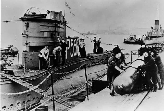 World War II Wrens loading a torpedo onto a submarine at HMS Dolphin, Gosport. The News PP5376