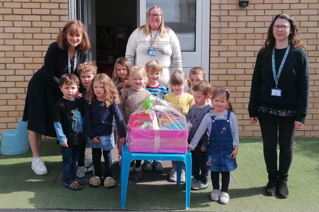 Matlock Pre-School Playgroup staff (from left) Liz Neil, Katy Taylor and Julie Cox and some of the children show off one of the Easter raffle prizes donated by generous local
businesses.