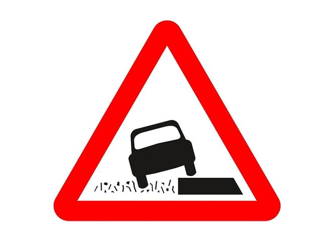 A. Grass banks ahead
B. Quayside or river bank
C. Uneven surfaces
D. Soft verges