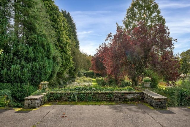 The grounds include a sunken garden enclosed by stone walling, summer houses and a fenced tennis court.