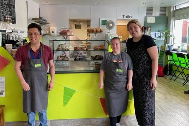 Christopher Rhodes, Abigail Brummitt and Emily Anderson at the cafe by some of the cakes, brownies and scones prepared in-house.