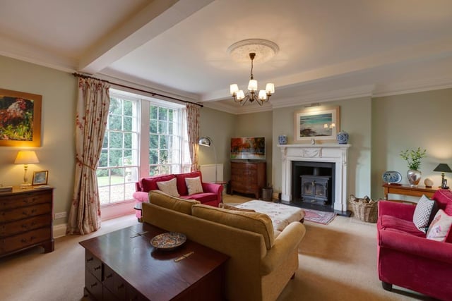 The drawing room has a high ceiling and views over the gardens and surrounding countryside. The focal detail of the room is an ornate Georgian white marble fireplace and polished slate hearth with a wood burning stove set within.