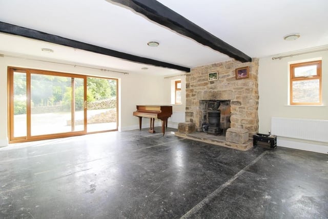 A stone fireplace is the focal point of the spacious lounge where there is a sliding door out to the rear of the cottage.