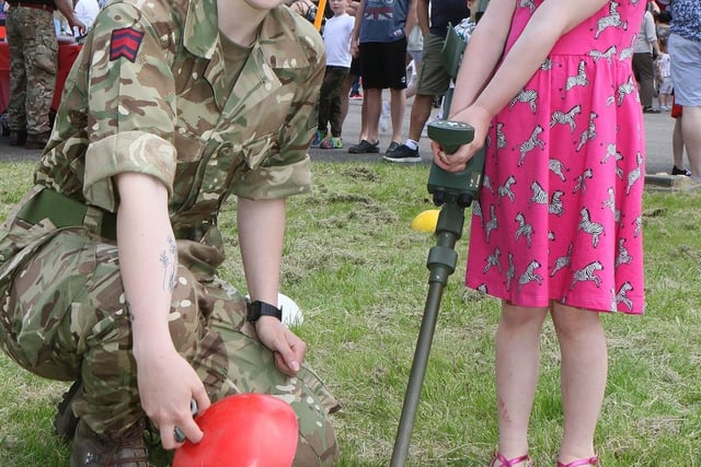 Amelia Thorpe from 106 Field Squadron explains the mine detector to Elsie Pearson.