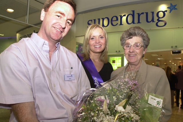 Hollyoaks actress Danielle Brent presents first customer Sylvia Atkins with a bunch of flowers from Store Manager Mark Hague as she  opens the new Superdrug store in 2001