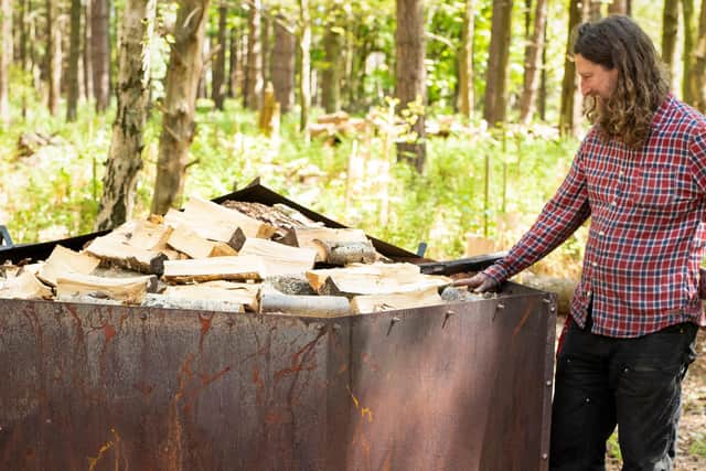 Wood-collier Matthew Robinson checks kiln before lighting.