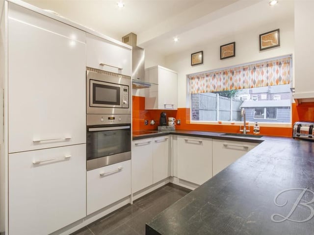 Neutral range of white gloss wall and base units incorporating drainer sink unit with complimentary splash backs. Fitted with a range of integrated appliances including fridge freezer, dishwasher and washing machine.