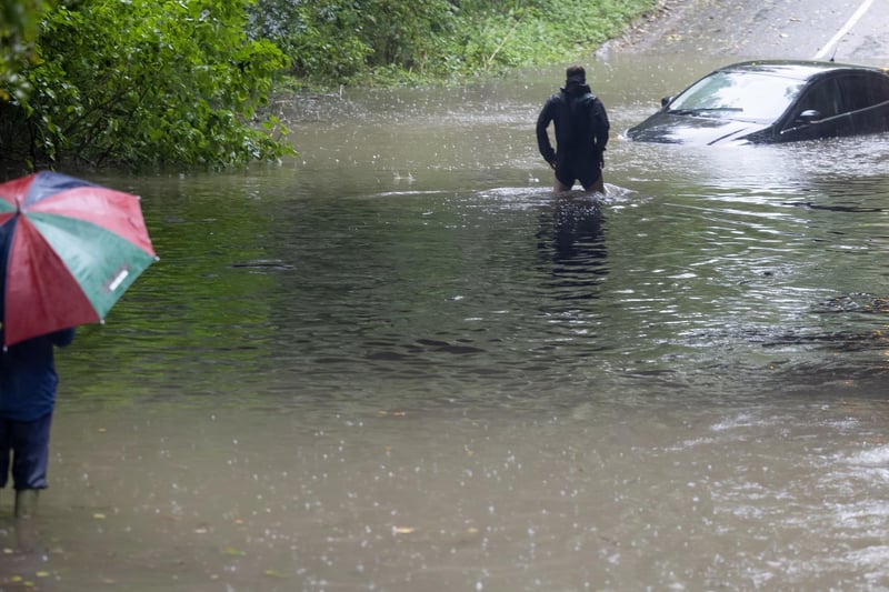 A ‘Good Samaritan’ wades in to flood-water on Wyaston Road, Ashbourne, to check if anybody is still inside a car stranded in deep water as storm Babet brings torrential rain across the country. RKP Photography