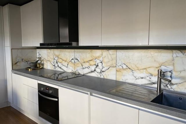 The kitchen has integrated appliances and Italian Calacatta Paonazzo marble tiles.