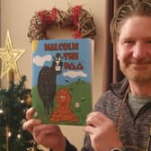 Simon Hucknall with the children's book he has written and illustrated.