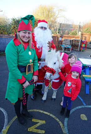 Tibshelf Infant and Nursery School Christmas Market. Pictured are Emily Jones, Tabitha Martin with Santa, helper and Christmas pony.