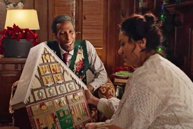 Gramps, played by Ron Cephas Jones, presents the antique Advent calendar to his granddaughter Abby Sutton, played by Kat Graham, in The Holiday Calendar.