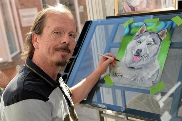 Tony works on a pet portrait in the shop.