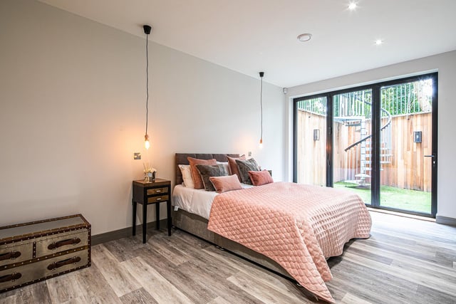This is one of the property's five bedrooms - note the spiral staircase in the garden outside, easily accessible through the stylish patio doors.